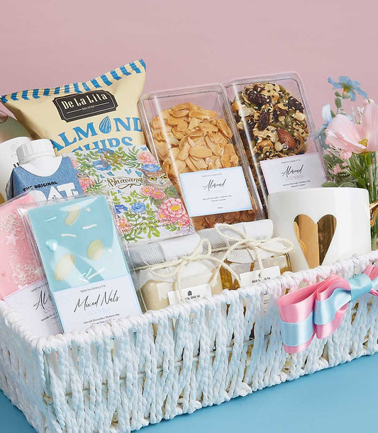 Woven gift basket filled with gourmet treats, cookies, and artisan jars, topped with heartfelt mug for Mother's Day
