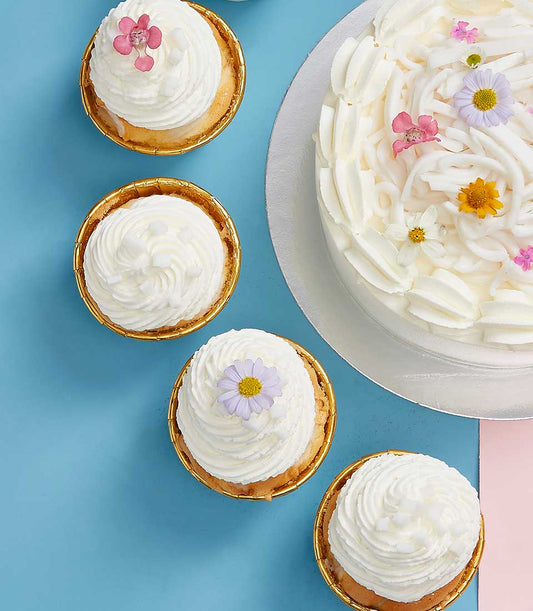 White coconut cake and cupcakes with edible flowers, Mother's Day celebration set from Charlotte Bakery