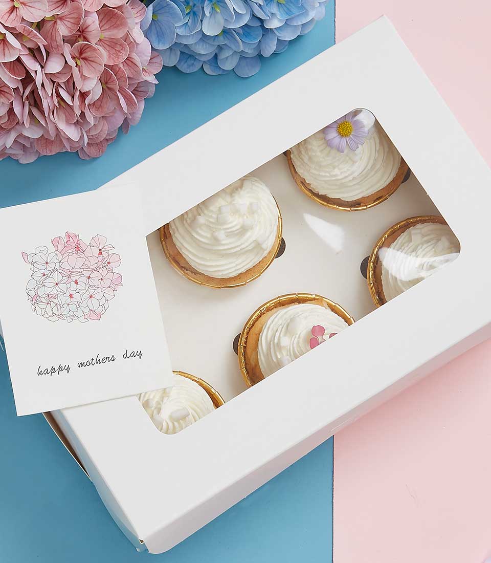 Coconut Joy cupcakes gift box with six cream-topped desserts, purple flower and pink hearts, Mother's Day card