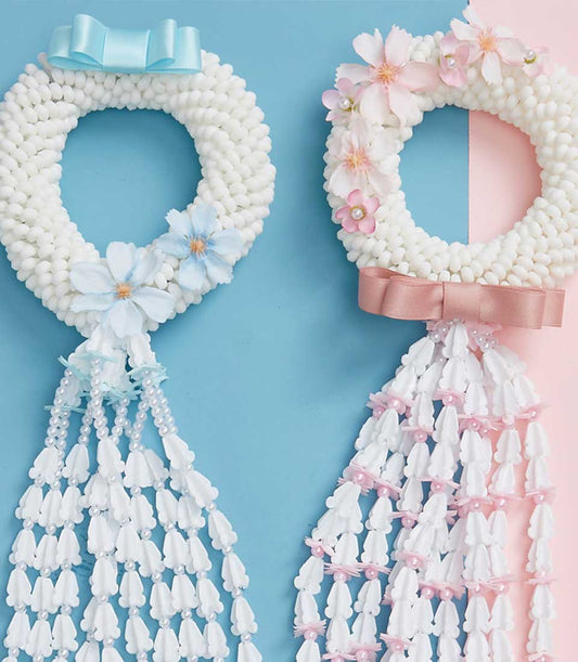 Traditional Thai Phuang Malai garlands with white buds, satin bows, and cascading pearl strands for Mother's Day