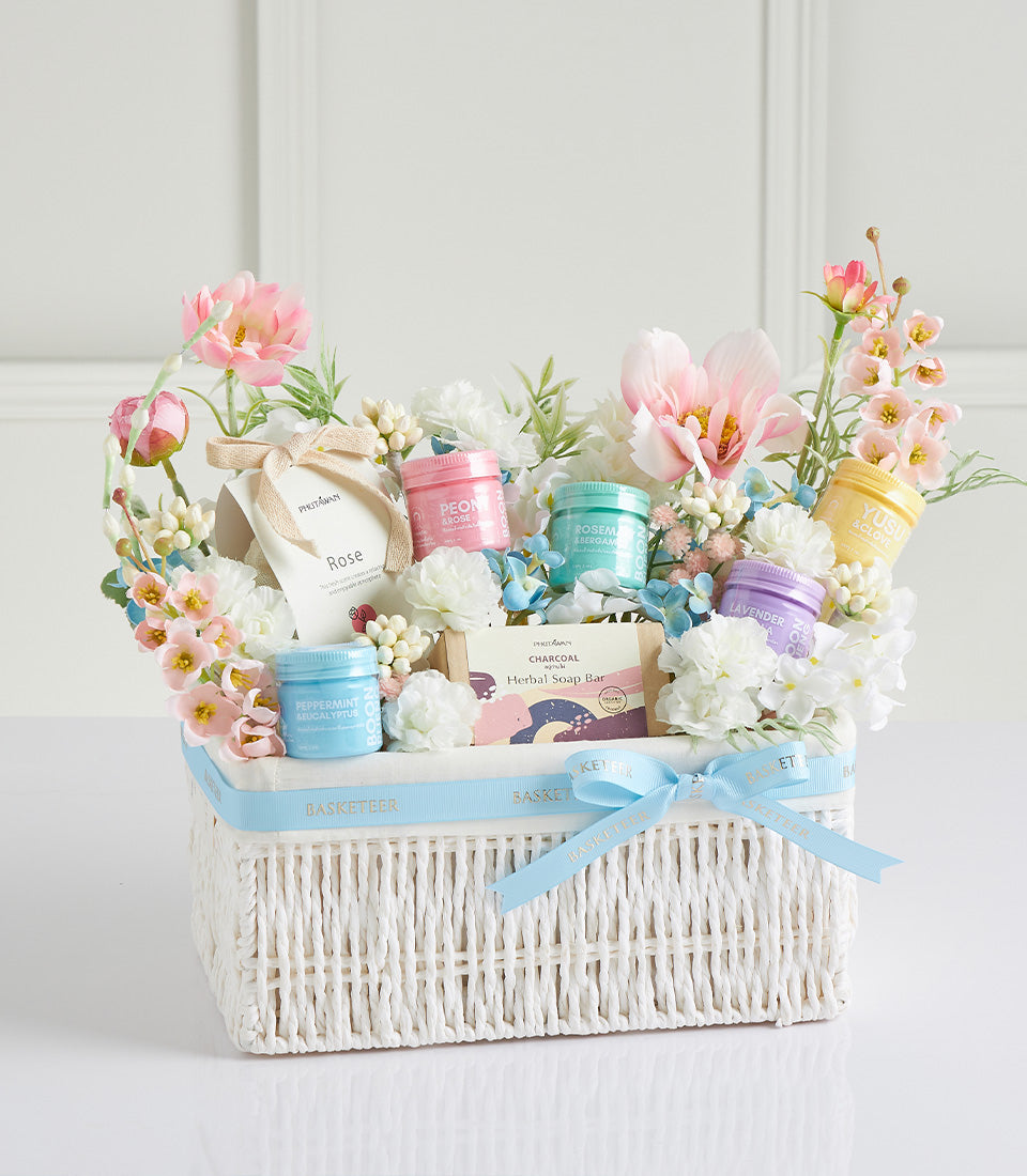 Luxury Mother's Day spa gift basket with herbal bath products, artisan soaps, and fresh florals in white woven basket