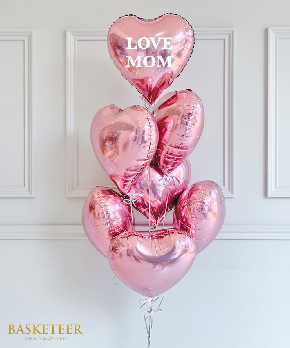 Pink heart-shaped foil balloon bouquet with Love Mom message and silver ribbons