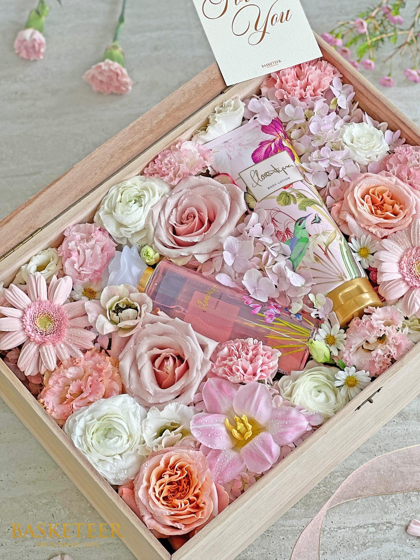 Premium spa gift box with fresh roses, hydrangeas, and gerberas alongside luxury bath lotion and foam bath for Mother's Day