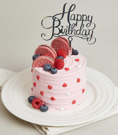 Berry and pink Oreo mini cake with heart sprinkles and fresh raspberries, topped with Happy Birthday topper
