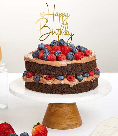 Two-tier chocolate ganache cake with fresh raspberries, blueberries, and strawberries for birthday celebrations