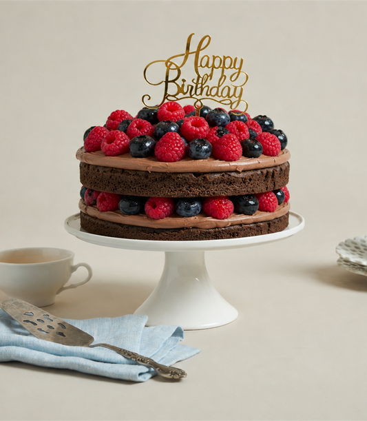 Charlotte Bakery artisan naked chocolate birthday cake, layered with creamy frosting and fresh raspberries