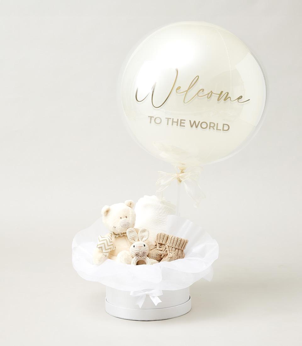 Tiny Wonders newborn gift box with plush teddy bear, crocheted bunny rattle, knitted booties, and baby blanket in white hat