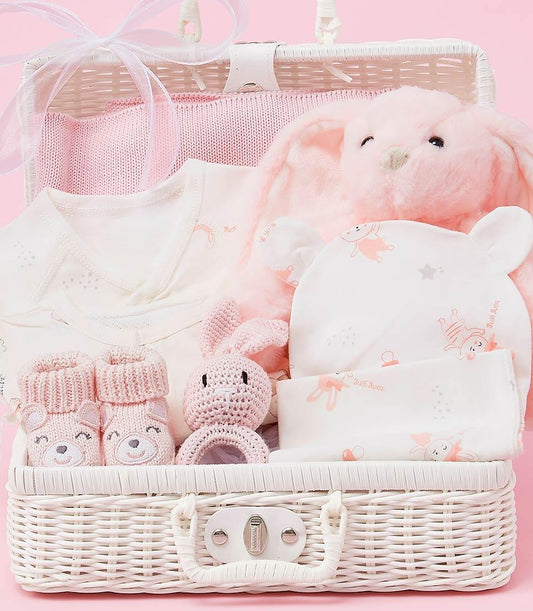 Luxury pink and white baby girl gift basket with plush bunny, knitted blanket, onesie, and booties