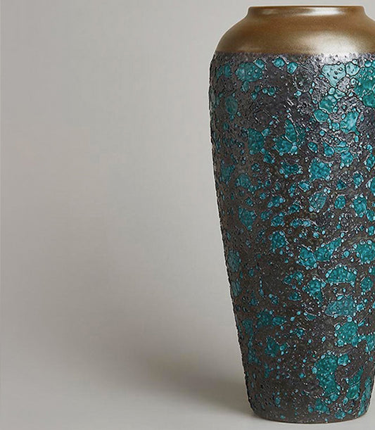 Tall ceramic vase with bronze metallic top and textured black body speckled with vibrant turquoise mosaic patches