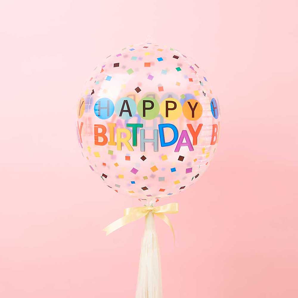Clear confetti happy birthday balloon with colorful letters and cream satin ribbon tassel