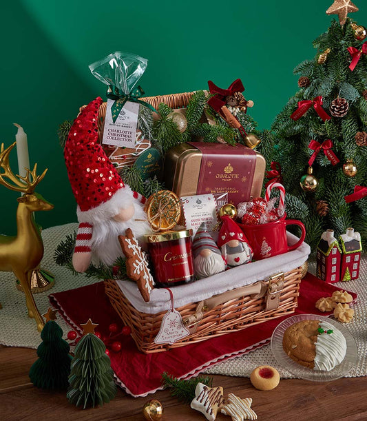 Festive Christmas gift basket with red wicker, gnome plush, holiday cookies, candle and festive mugs