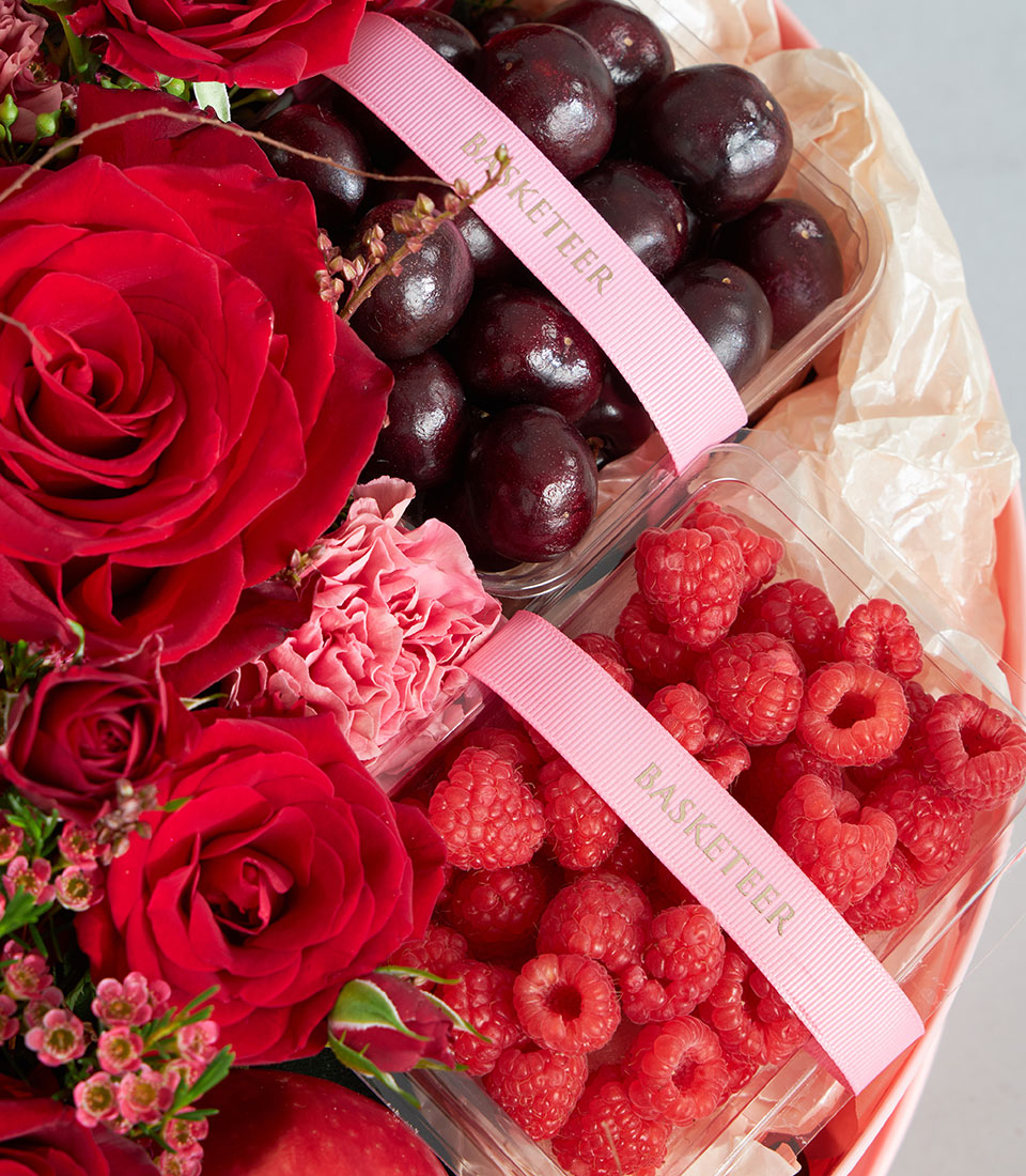 Luxury red fruit and floral round gift box with fresh cherries, raspberries, and premium roses for birthday celebrations