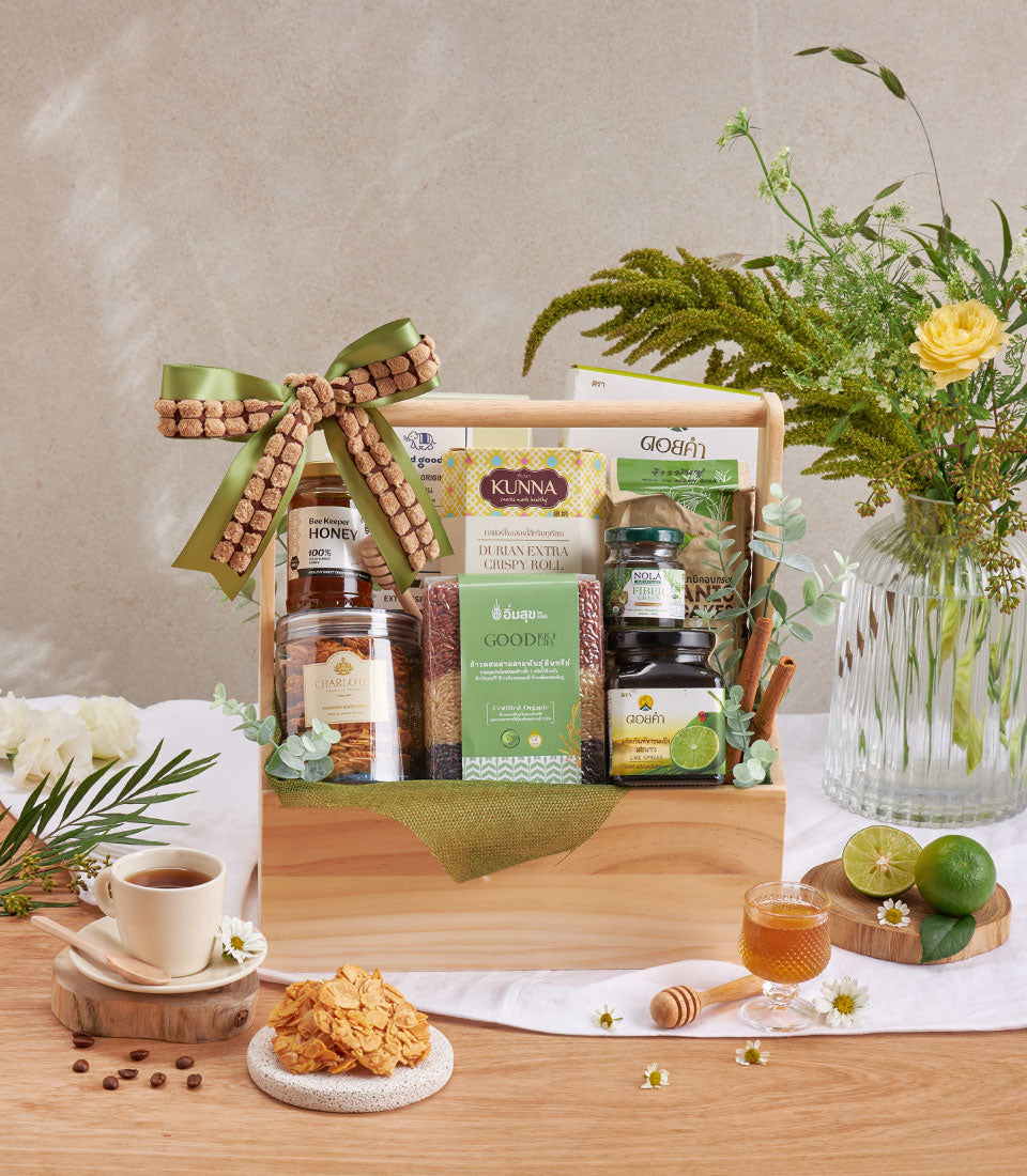 Wellness gift basket with healthy coffee, honey, crispy durian roll, and gourmet treats tied with green ribbon