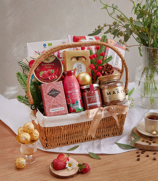 Woven gift basket with strawberry drops, gourmet chocolates, pomegranate juice, strawberry jam, and premium coffee