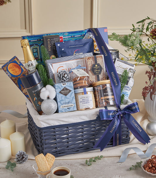 Blue woven gourmet gift basket with champagne, coffee, tea, and artisan treats for New Year celebrations