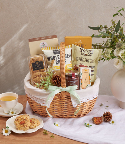 Premium wellness gift basket with gourmet cookies, jam, and healthy snacks in wicker with white lace trim