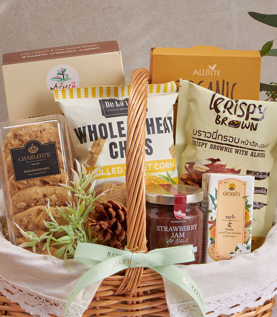 Woven wicker wellness gift basket with organic cookies, whole wheat chips, almond brownies, and strawberry jam