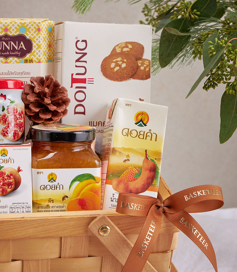 Premium wellness gift basket with herbal teas, gourmet snacks, and artisan preserves in woven wood