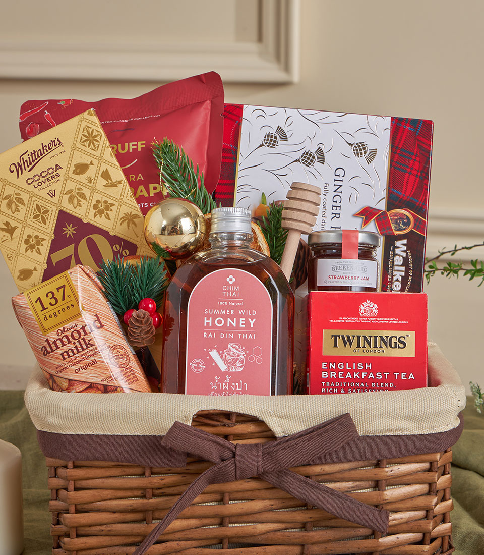 Woven wicker gift basket with honey, tea, chocolate and gourmet treats for New Year gifting