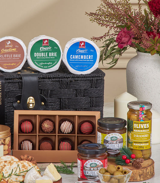 Luxury black woven gourmet basket with Brie, Camembert, artisan chocolates, chutneys, and olives