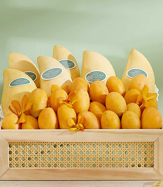 Wooden tray of Thai Nam Doc Mai and golden mangoes with orchid blooms, premium summer fruit gift hamper