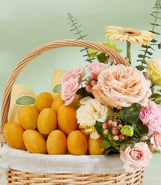 Luxury wicker gift basket with premium Thai Nam Doc Mai mangoes and peach roses, pink carnations, and yellow gerbera