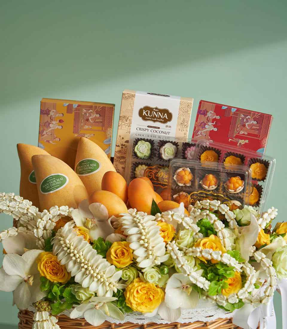 Songkran blessing gift hamper with Nam Doc Mai mangoes, Thai desserts, coconut crackers, and fresh orchids with yellow roses