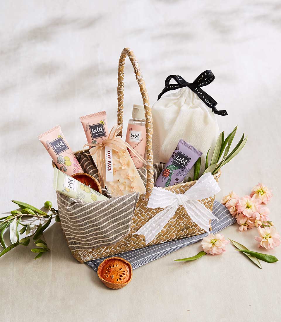 Luxury spa and skincare gift basket with Lalil beauty products, cream pouch, pink flowers, and decorative botanicals for