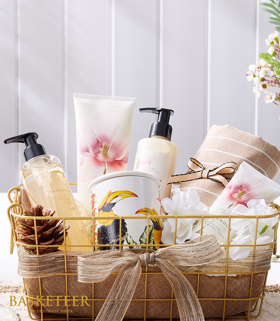 Gold wire mesh spa gift basket with magnolia hand wash, moisturising creams, ceramic toucan candle, and striped towel