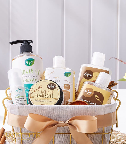 Gold wire spa gift basket with white bottles, rice milk cream scrub, and lemongrass shower gel tied with gold ribbon