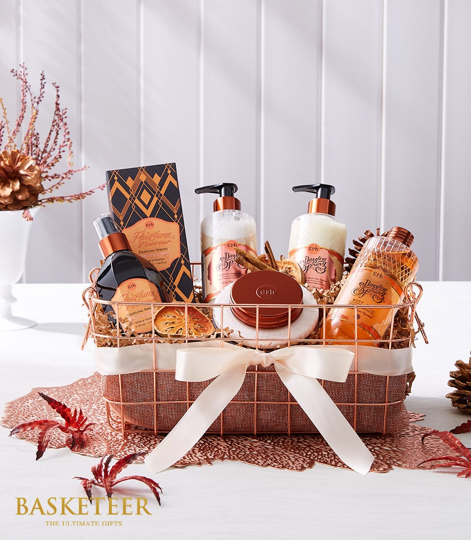 Rose gold wire mesh spa gift basket with bath products, cream satin bow, and autumn botanicals