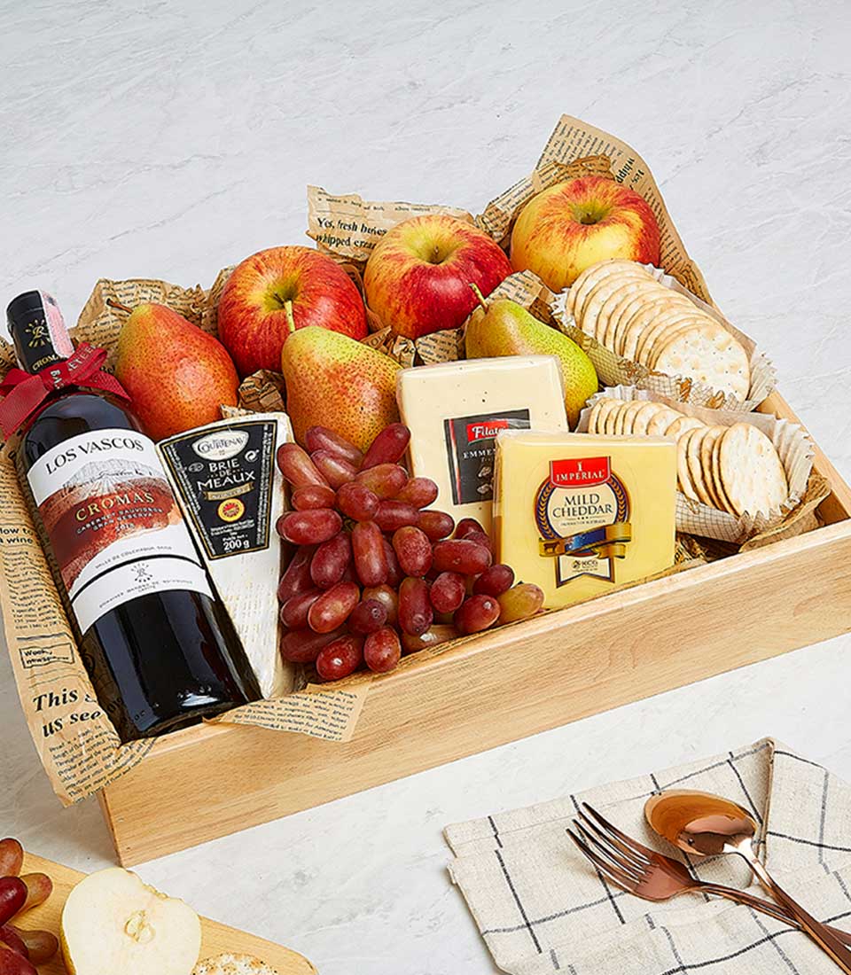 Premium wine, cheese and fruit gift basket in wooden tray with Brie, cheddar, crackers and fresh produce