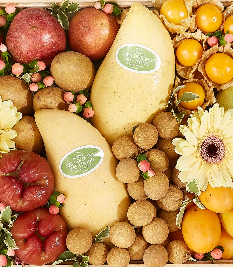 Tropical Harvest gift basket with Nam Dok Mai mangoes, rose apples, longans, physalis, and gerbera daisies in wooden crate