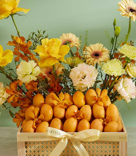 Premium tropical mango crate with yellow roses, gerbera daisies, and orchids in light wood gift box