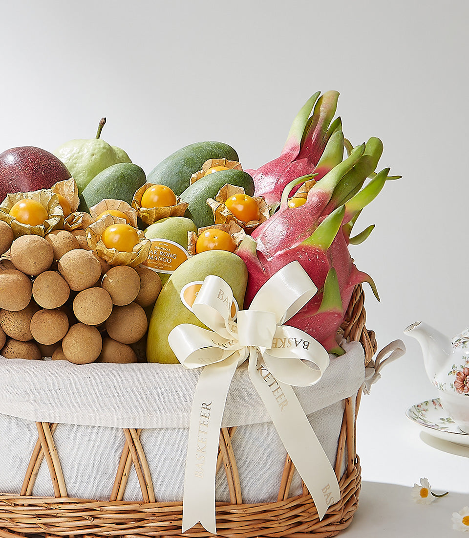 Exotic tropical fruit basket with longan, dragon fruit, mango, and passion fruit in woven wicker