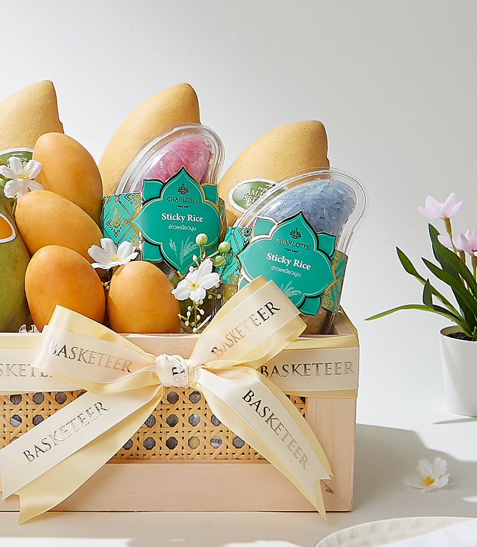 Tropical fruit gift basket with fresh mangoes, sticky rice, and cream satin ribbon