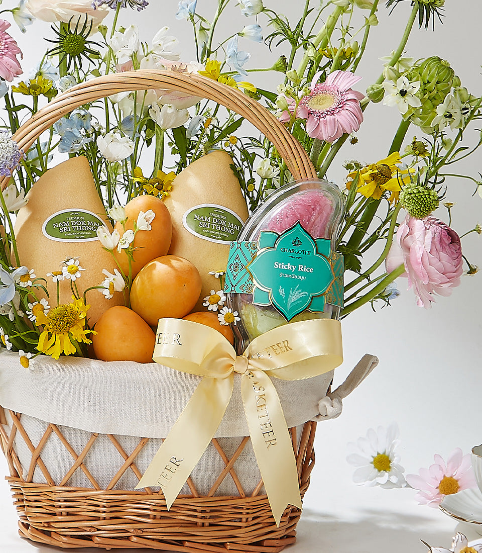 Premium Thai mango and persimmon gift basket with fresh flowers and sticky rice delicacy