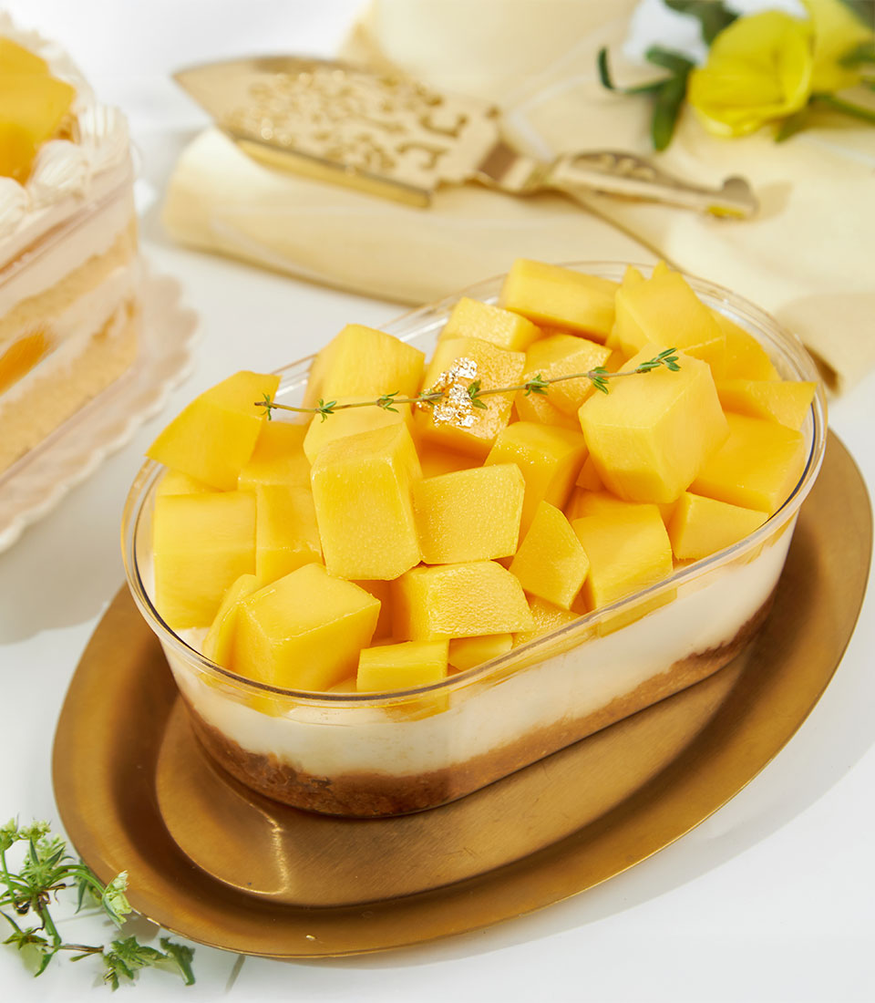 Golden mango biscoff cheesecake with diced mango topping in luxury gift box