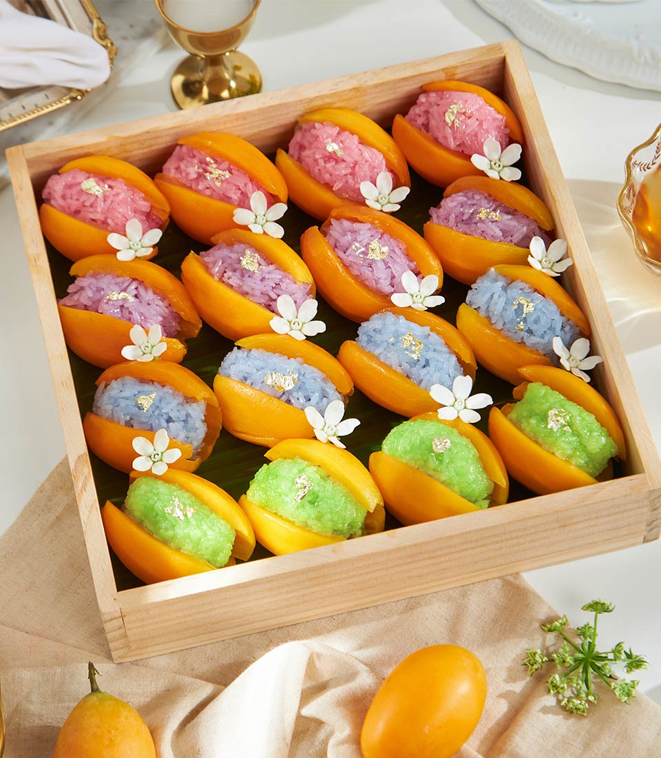 Rainbow pastel sticky rice with fresh mango in artisan wooden box, Thai tropical gift hamper