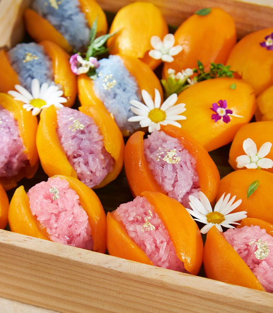 Mango sticky rice desserts with gold leaf in elegant wooden gift box