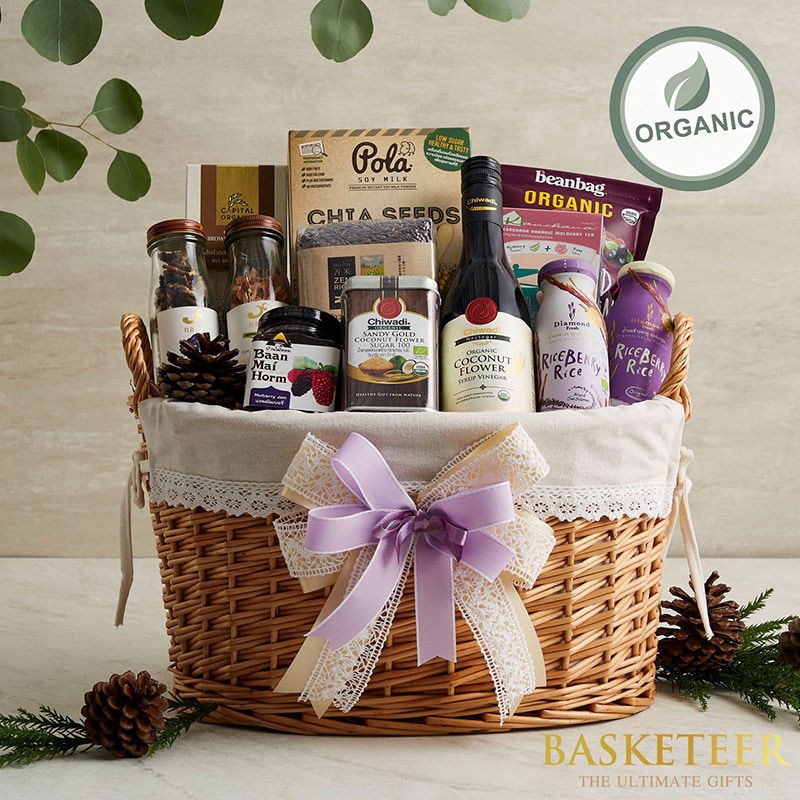 Light wicker gift basket with organic Thai wellness foods, lavender ribbon, artisan health-focused hamper