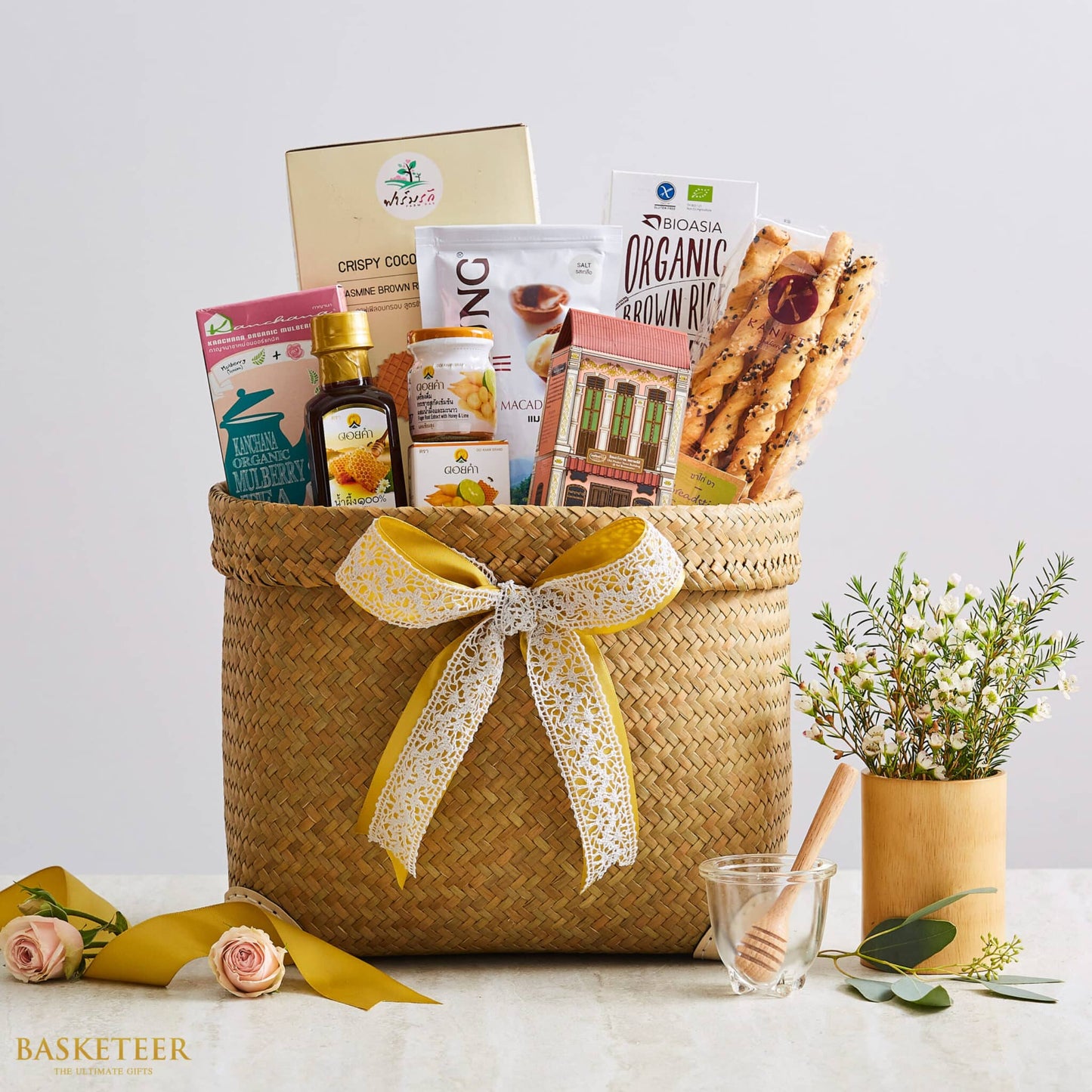 Woven natural fiber gift basket filled with organic brown rice, macadamia nuts, honey, jasmine tea, and wellness essentials,