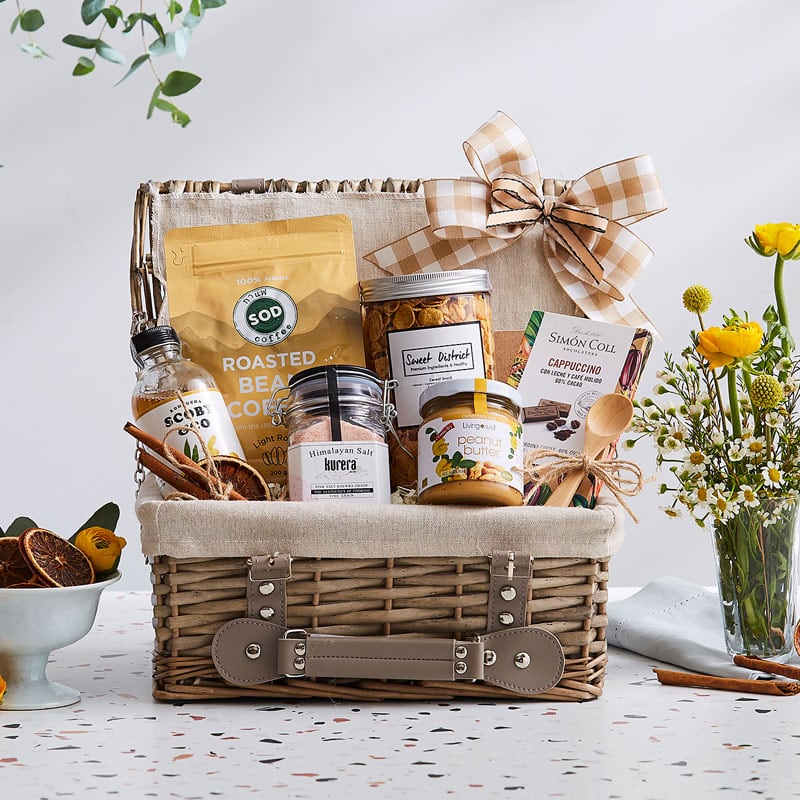 Curated tropical gift basket with roasted coffee, artisan chocolate, gourmet spreads, and wellness essentials in woven