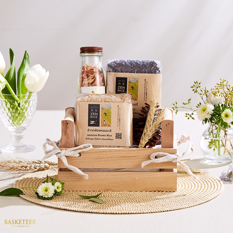 Premium Thai rice gift set in rustic wooden crate with Jasmine brown rice, dried herbs, wheat, and white floral accents