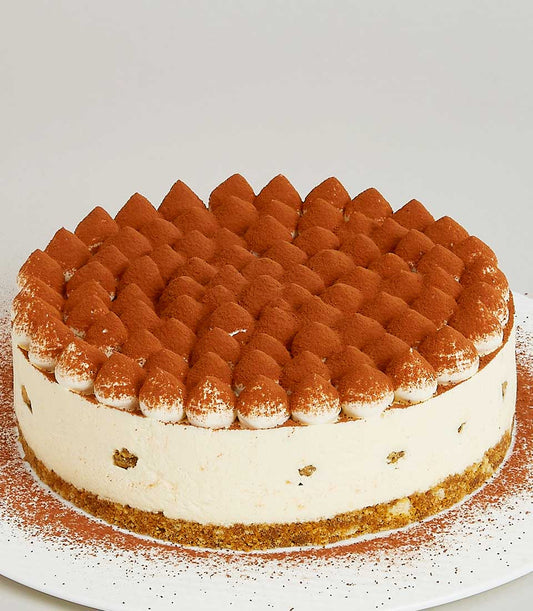 Tiramisu mascarpone cream cake with cocoa-dusted peaks and crushed biscuit border, artisan bakery gift