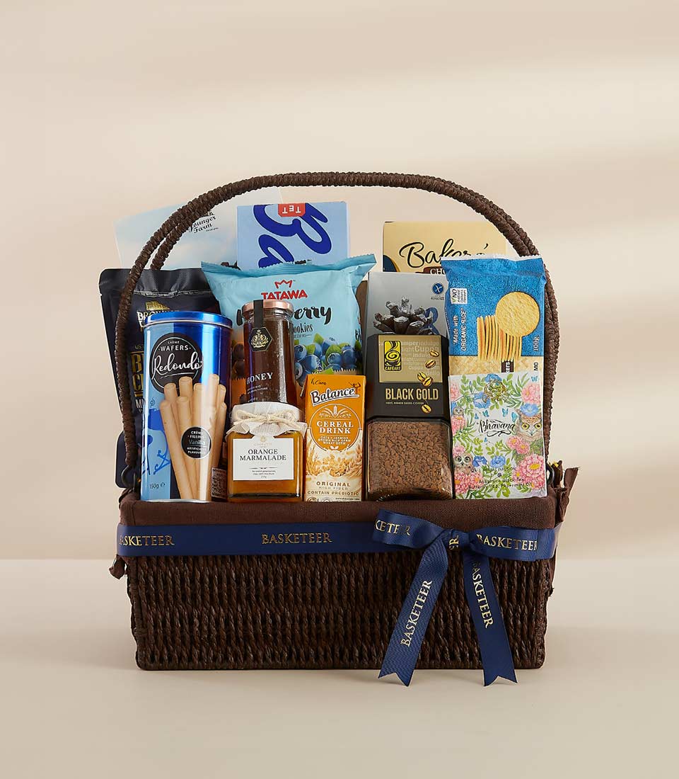 Woven dark brown gourmet gift basket with blue Basketeer ribbon, filled with honey, marmalade, coffee, wafers, and artisan