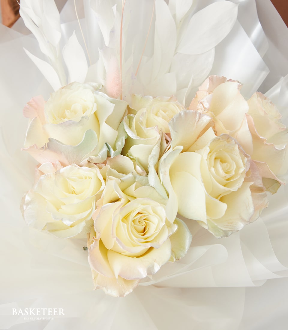Cream and pale pink roses with white organza wrap and leaf accents, Valentine's Day bouquet