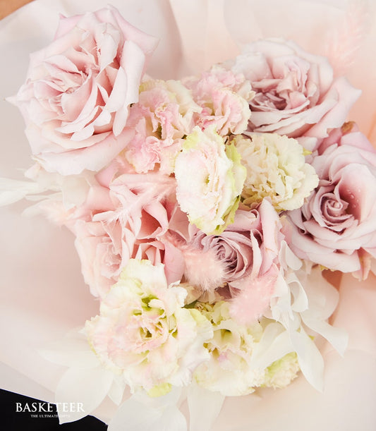 Blush pink rose bouquet with white lisianthus and feathers, wrapped in soft organza for Valentine's Day