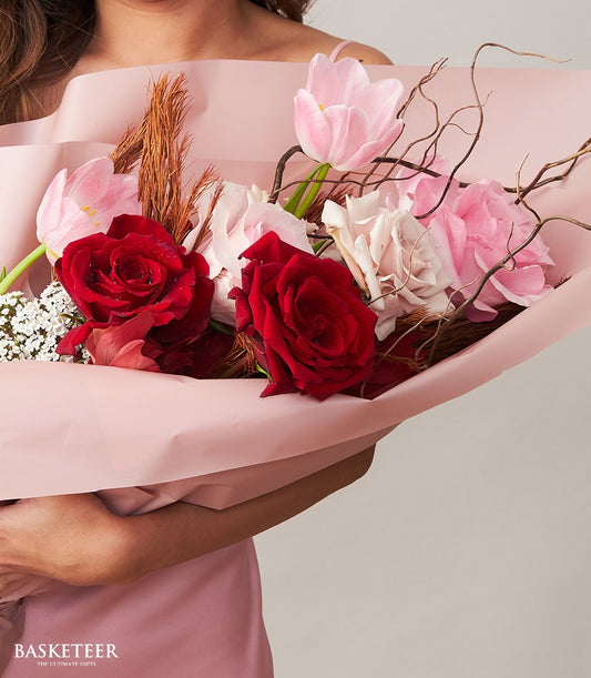 Red roses and pink tulips with cream blooms in light pink wrapping, Valentine's Day romantic gift bouquet