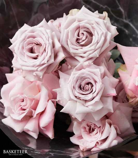 Soft pink and lavender rose bouquet with elegant dark wrap, perfect Valentine's gift for her